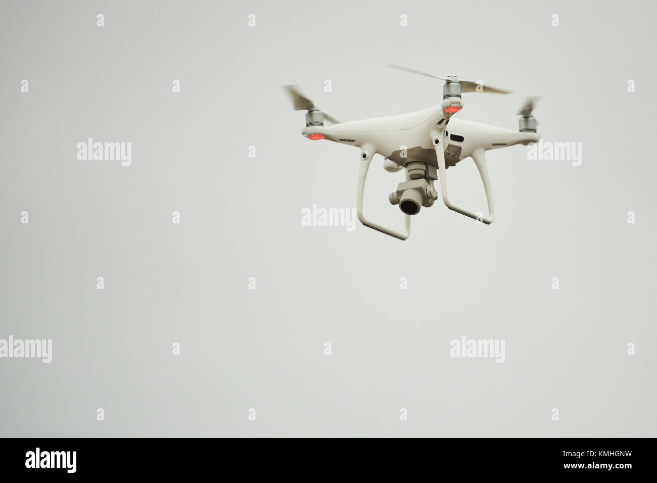 Minsk, Belarus - December 3, 2017: DJI phantom 4 pro drone fly at winter gray sky with camera filming down Stock Photo