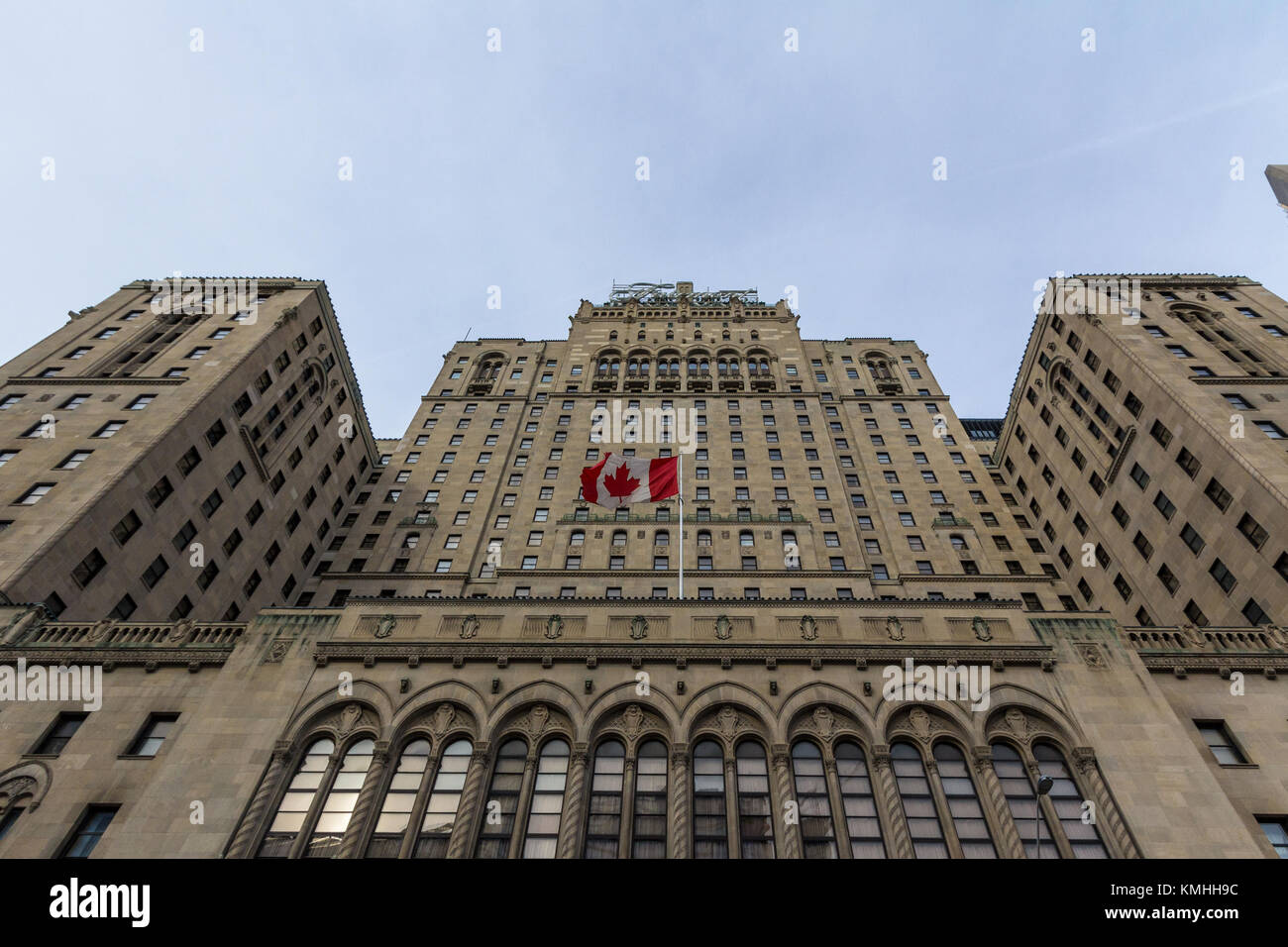 TORONTO, CANADA - DECEMBER 31, 2016: Fairmont Royal York hotel in Toronto, Ontario, seen from the bottom with a Canadian flag waiving. This luxury hot Stock Photo