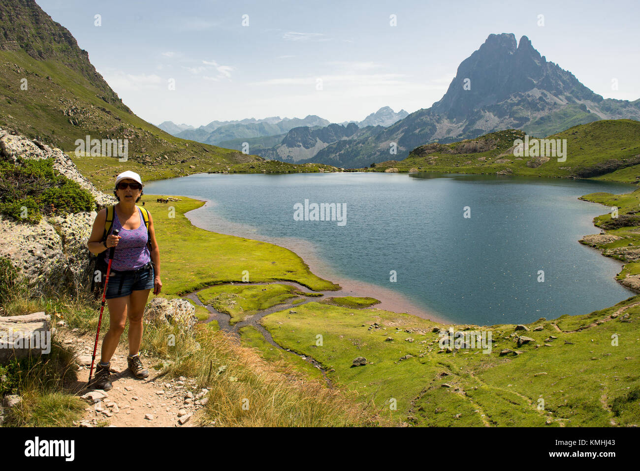 A woman hiking near a mountain lake in the French Pyrenees Stock Photo ...