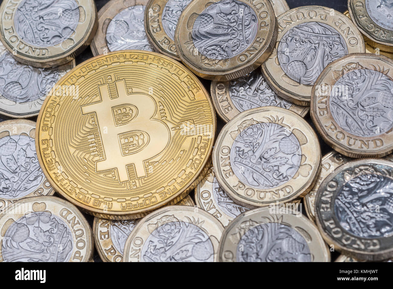 Gold colored Bitcoin and pound / £ coins - the peer-to-peer payment cryptocurrency reaching high levels in December 2017, 2020 Bitcoin crash. Stock Photo