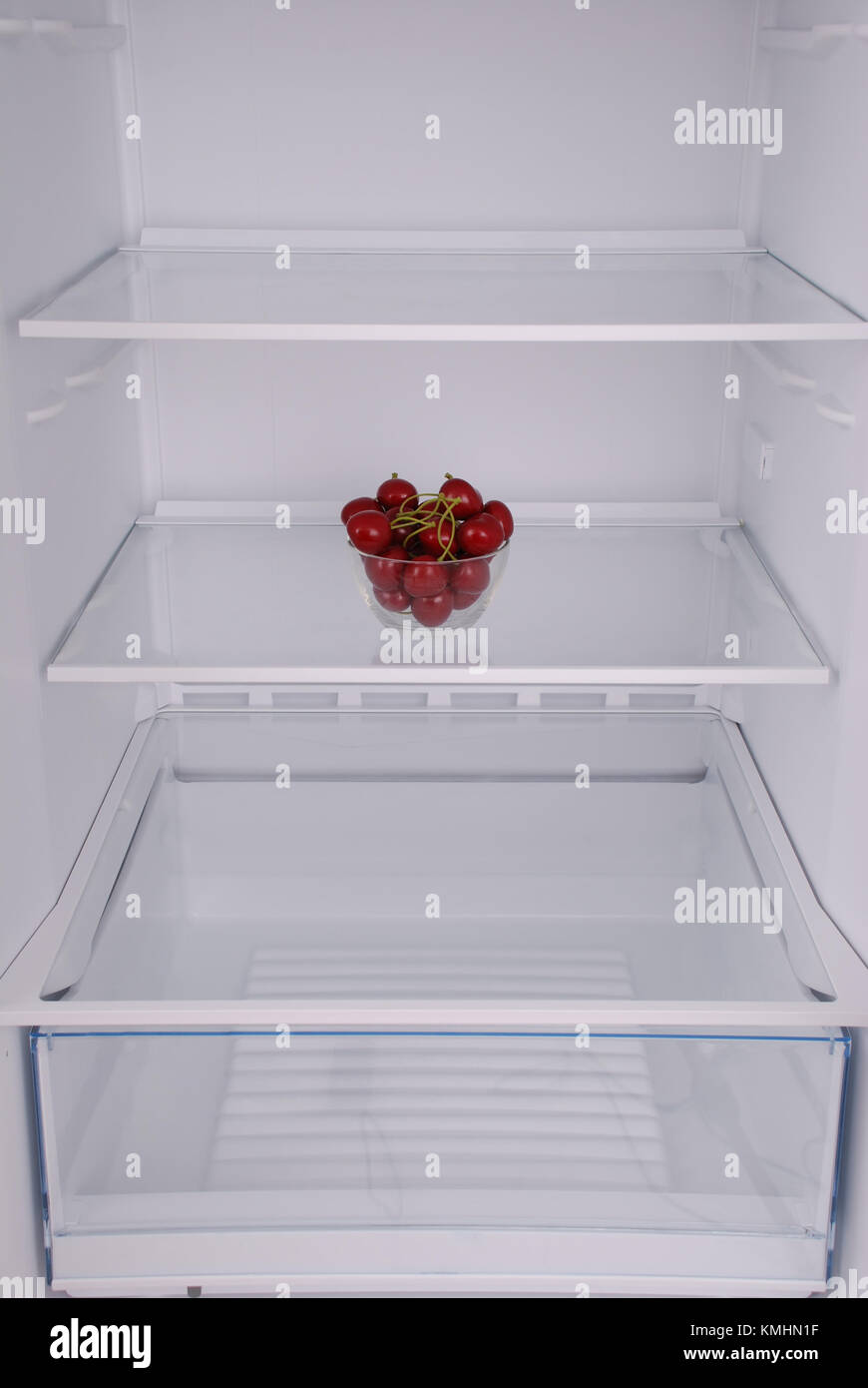 Cherries in open empty refrigerator. Weight loss diet concept Stock