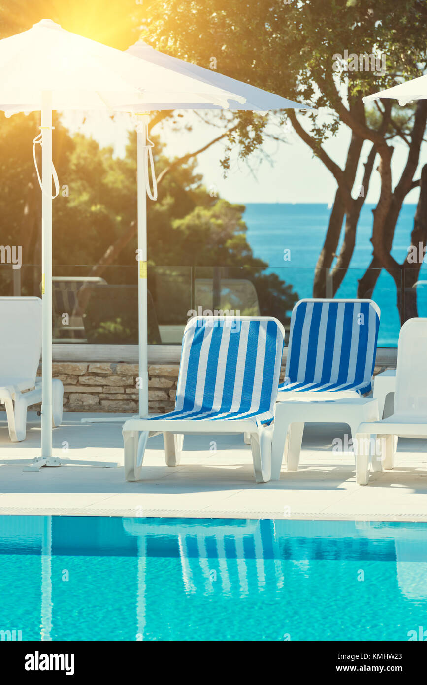 sunbeds and umbrellas by the swimming pool on a sunny day Stock Photo ...