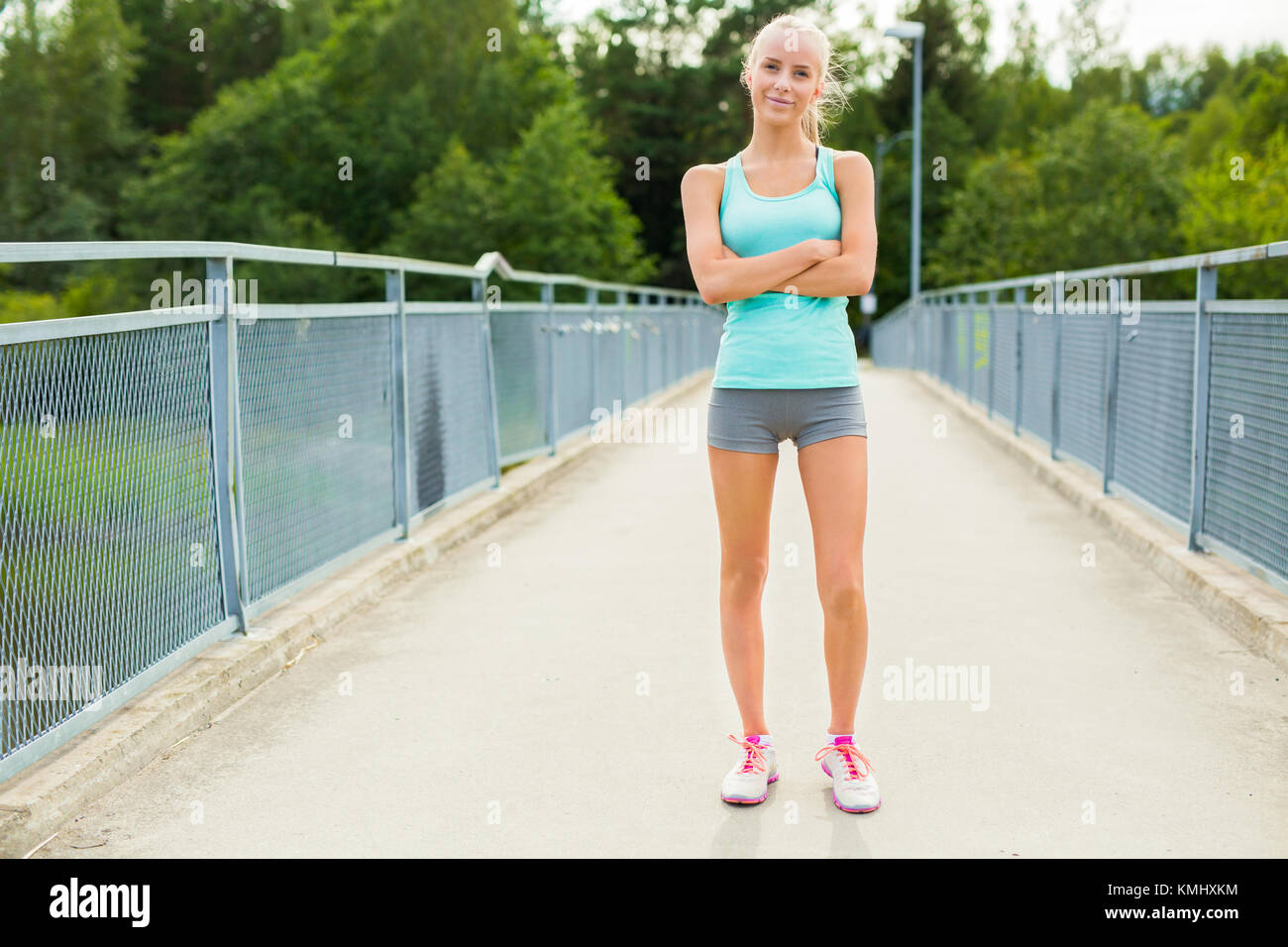 Confident and smiling young female runner having break after workout Stock Photo
