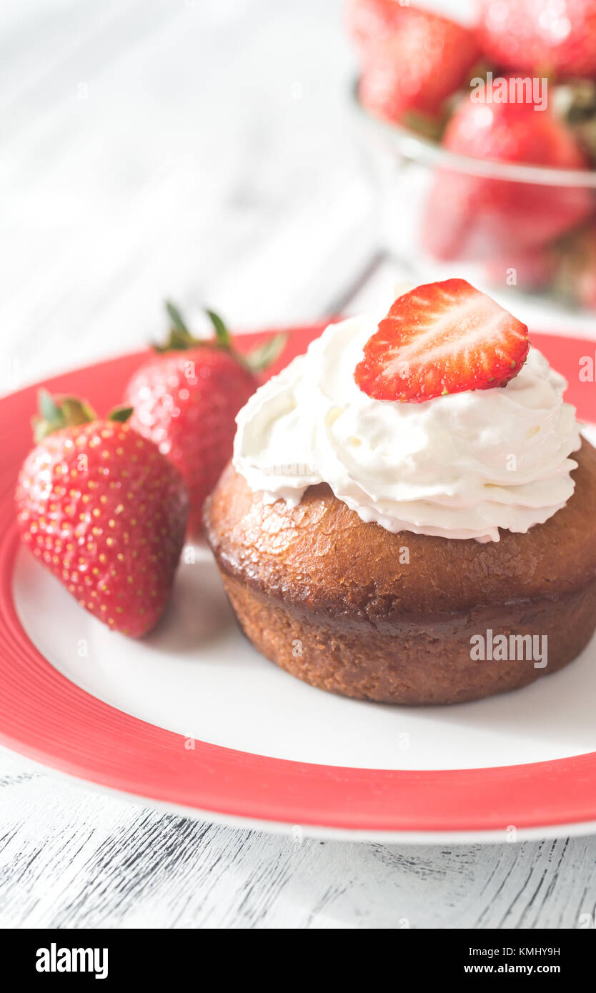 Rum baba decorated with whipped cream and fresh strawberries Stock