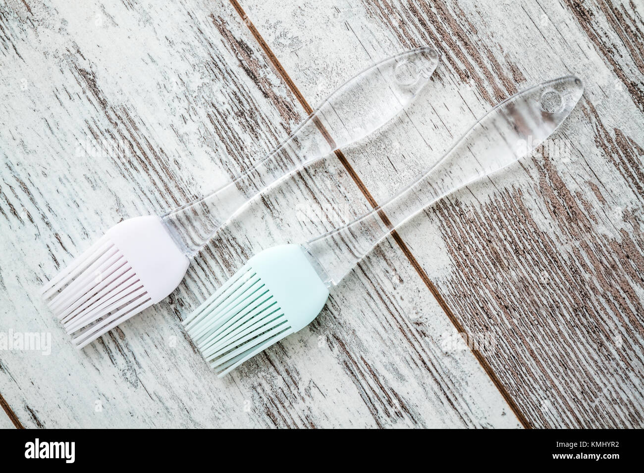 Silicone cooking brushes with transparent handles on white wooden