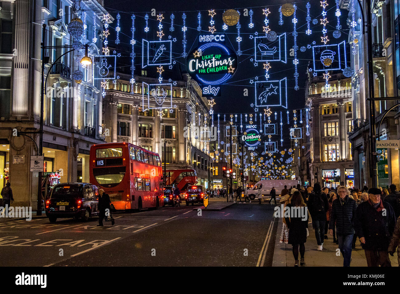 Christmas shoppers at Christmas on London's Oxford St, under The Oxford