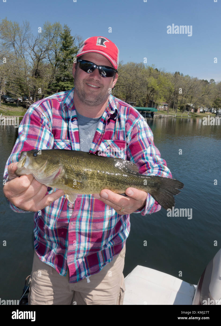 Angler holds up a nice size bass. Caught while fishing on the Gull chain of lakes. Nisswa Minnesota MN USA Stock Photo