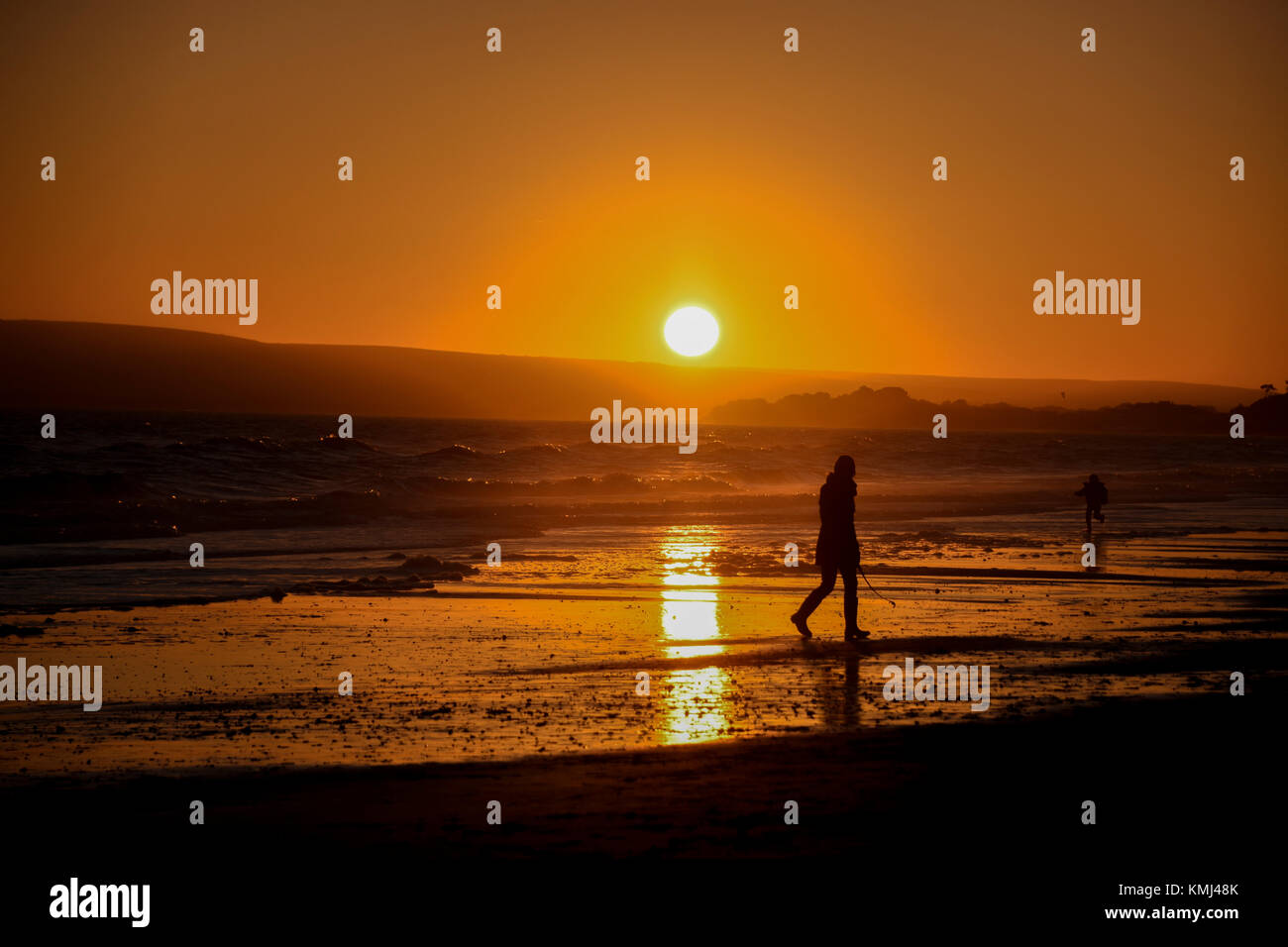 People on the beach  at sunset in  Silhouette Stock Photo