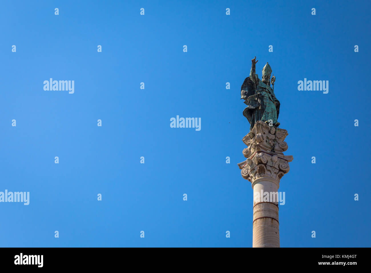 The symbol of Lecce town (Italy): Saint Oronzo (Sant'Oronzo) posed on the column at the center of the main town Square. Blue backgroud with copy space Stock Photo