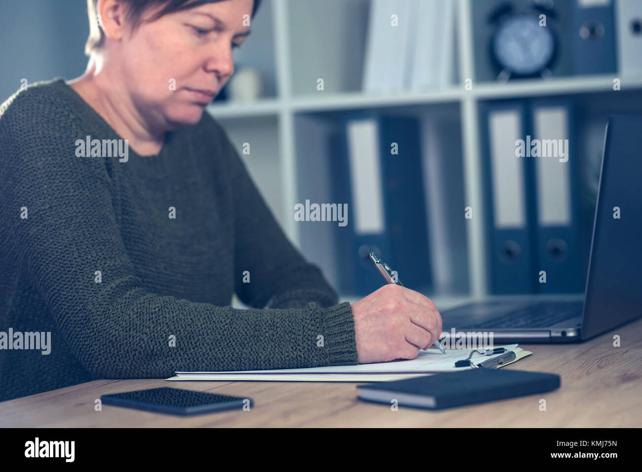 Female entrepreneur signing business contract agreement in home office interior Stock Photo