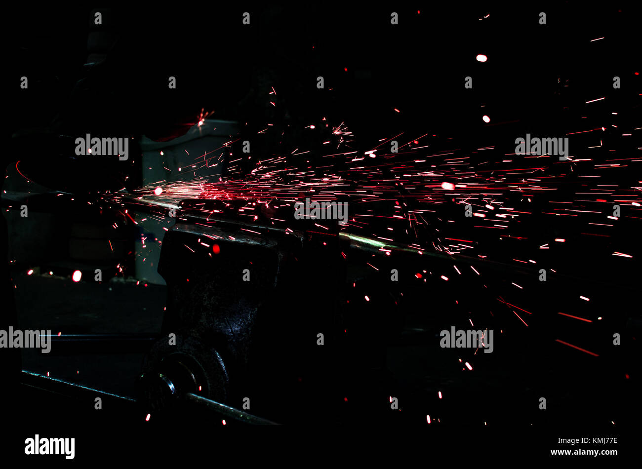 Industrial grinder showers sparks while working with metal. Stock Photo