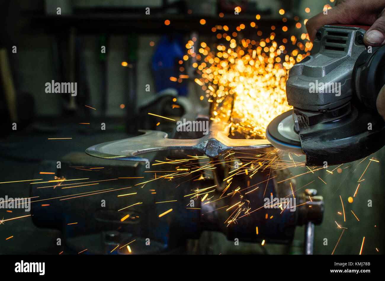 Industrial grinder showers sparks while working with metal. Stock Photo