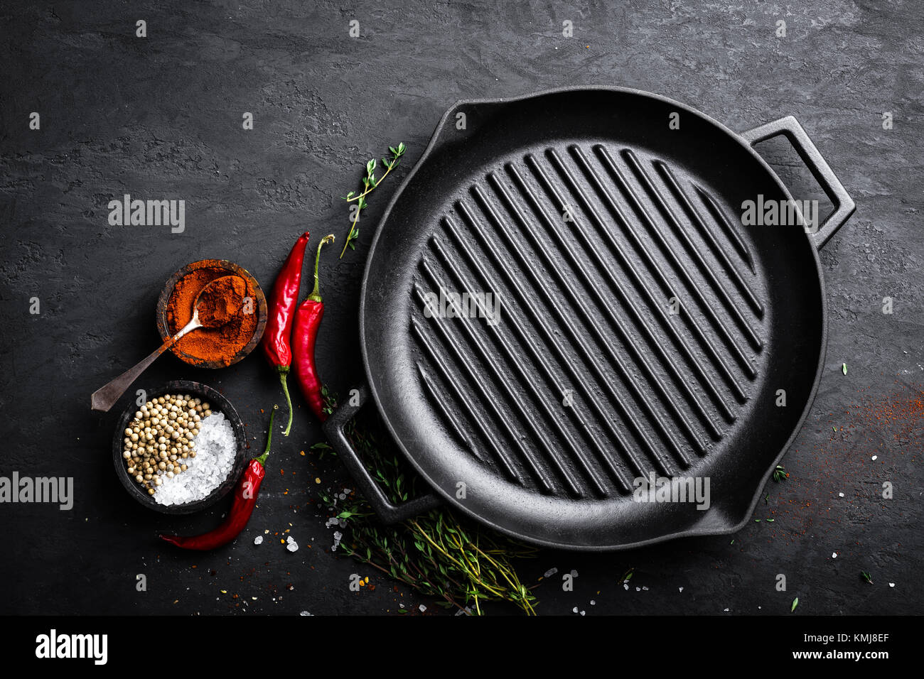 Empty castiron grill pan with ingredients for cooking on black