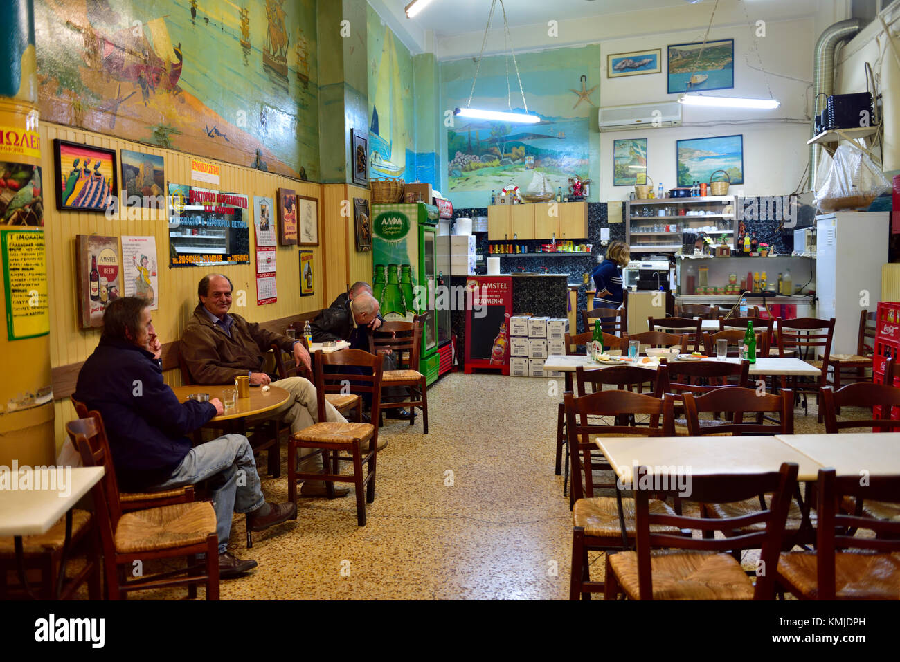 Inside traditional local Greek cafe, ouzo bar with locals relaxing over