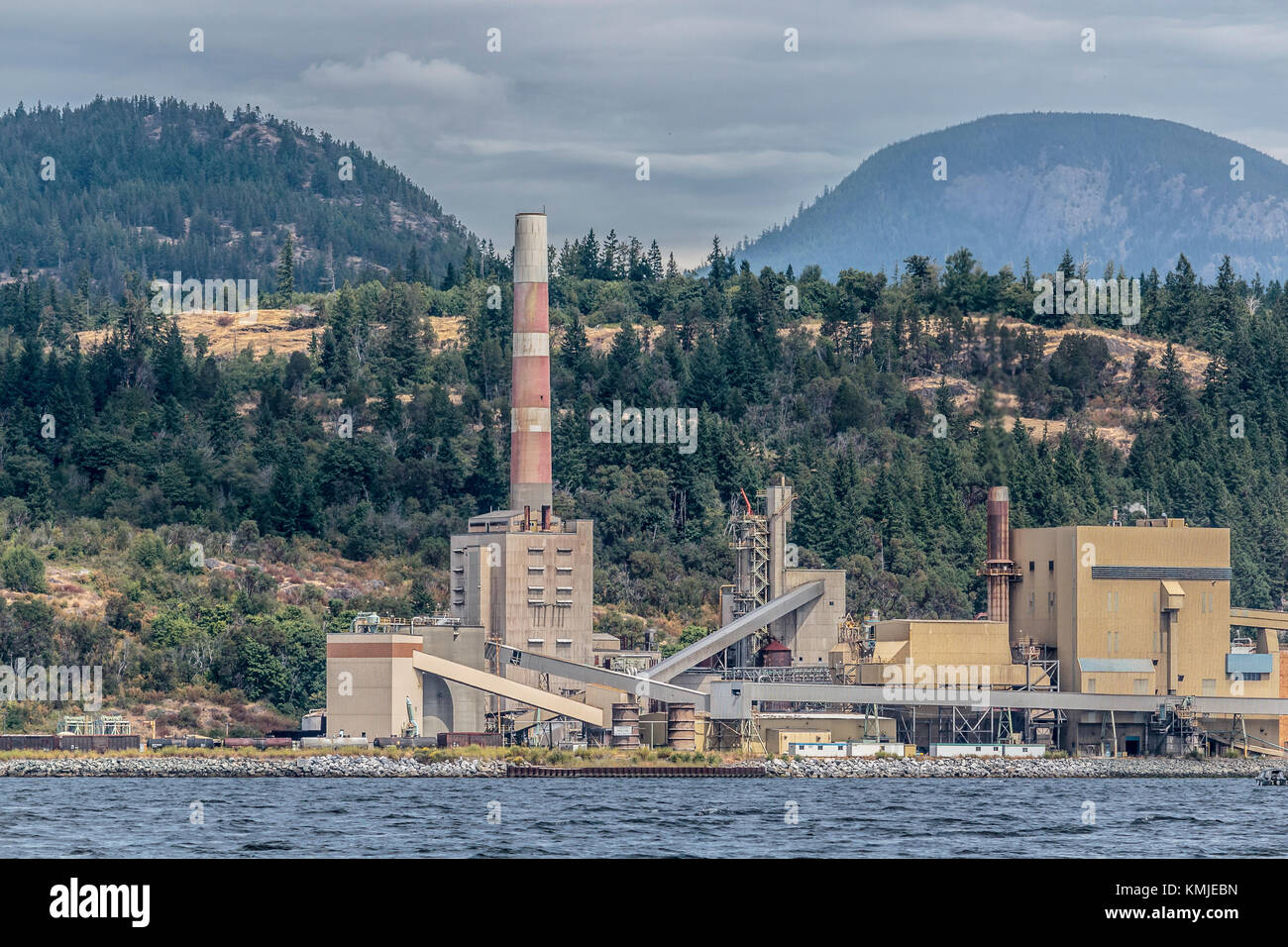 The smokestack at Catalyst Paper's Powell River (tiskwat) Mill is a visible and historic landmark on BC's Sunshine Coast. The mill shut down in 2021. Stock Photo