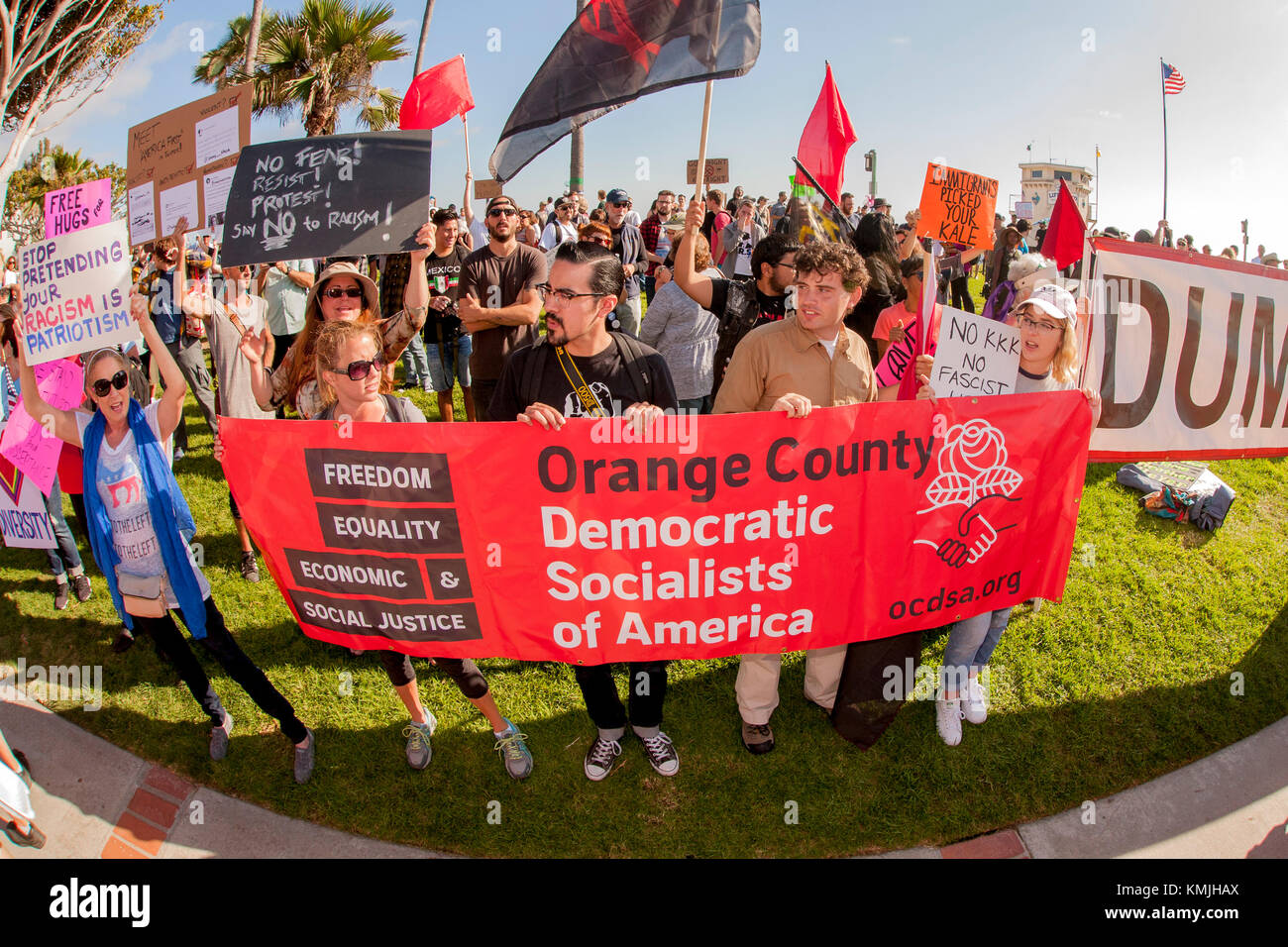 Multiracial counter demonstrators display their signs in Laguna Beach, CA, in opposition to an adjacent anti-immigrant rally on the city's Main Beach. Stock Photo