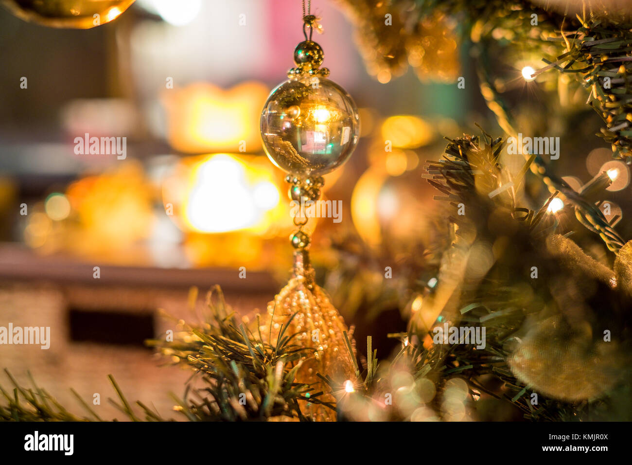 Christmas tree with baubles, trinkets and lights, in golden colours with a rustic, homely feel Stock Photo