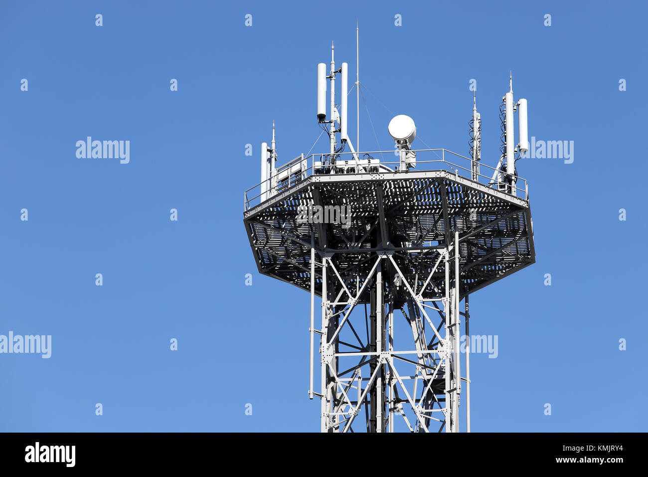 View of communications tower with antennas against blue sky Stock Photo