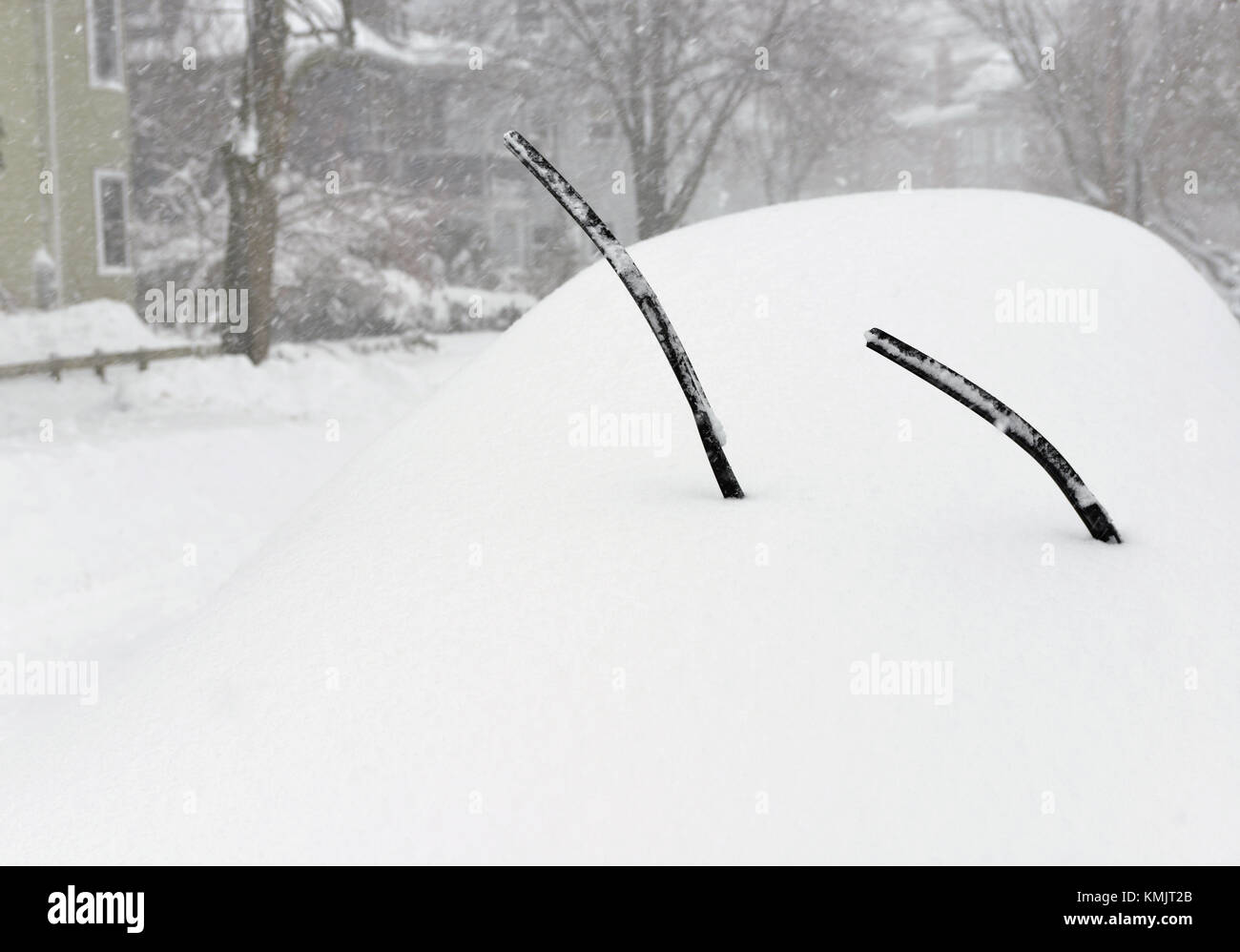 Car covered in snow, windshield wipers sticking out Stock Photo