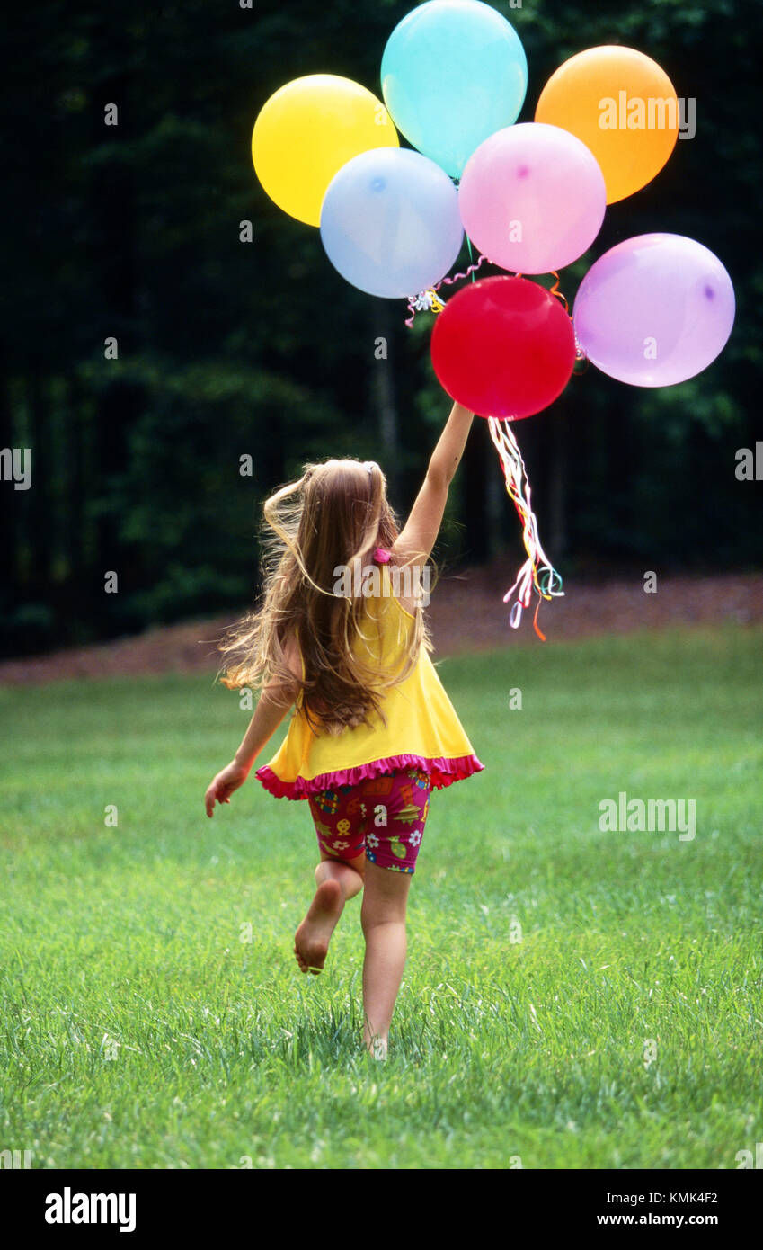 Girl running with balloons Stock Photo Alamy