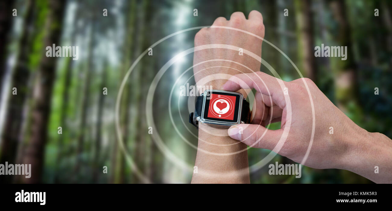 Cropped image of man using watch against digital composite of heart icon Stock Photo