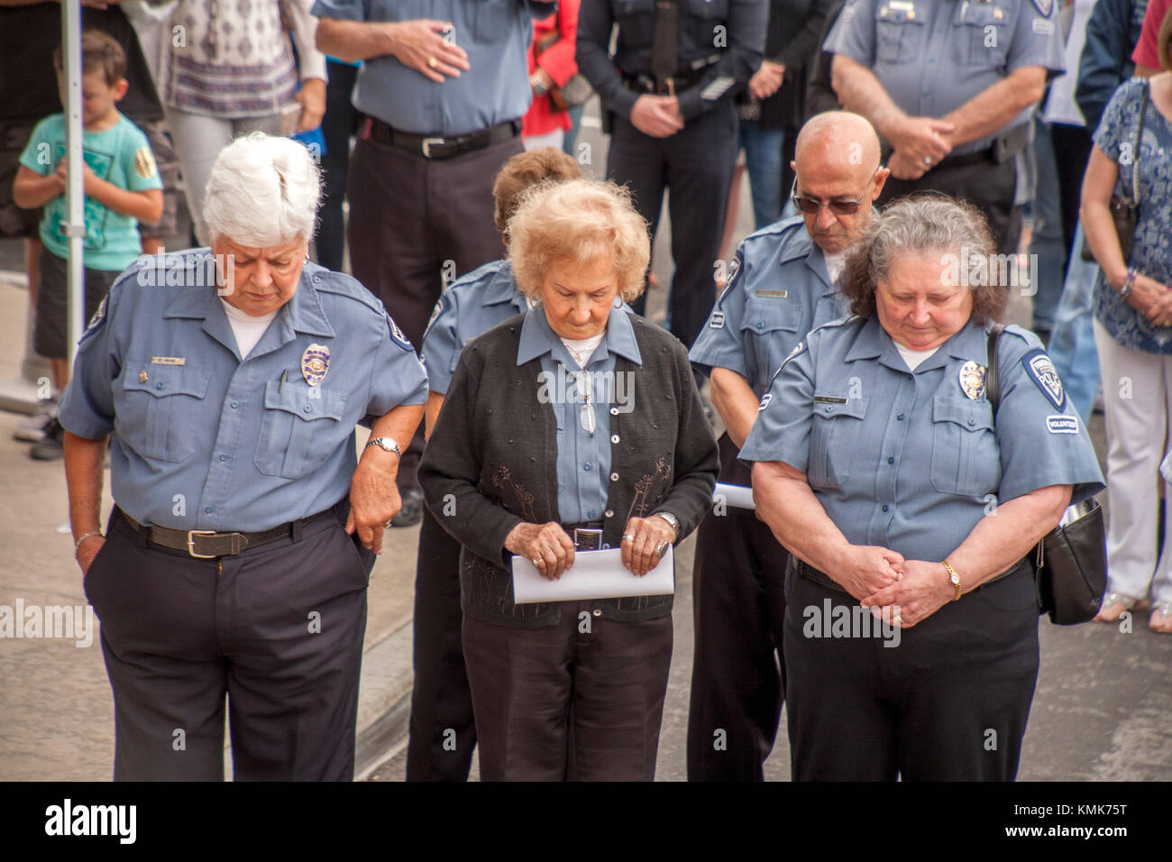 Elderly police volunteers bow their heads during the National Anthem.  (Photo by Spencer Grant) Stock Photo