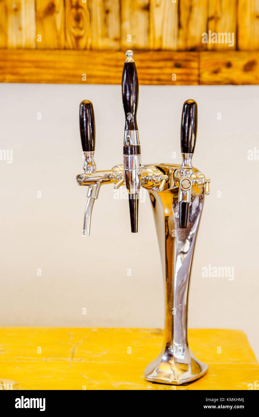 Close up of multiple beer taps located over a wooden table in a blurred background Stock Photo