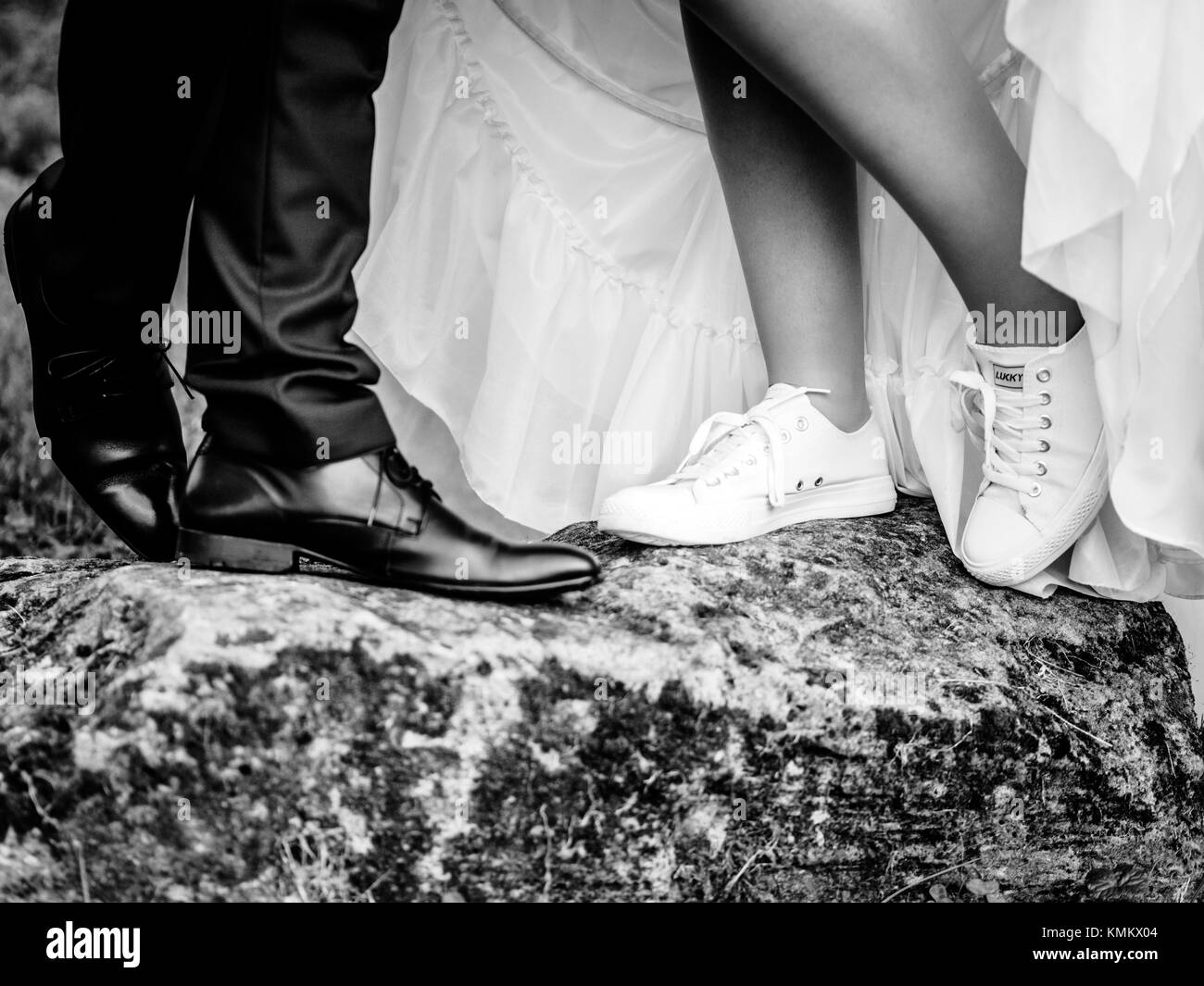 The bride wears sneakers for her wedding black and white Stock Photo