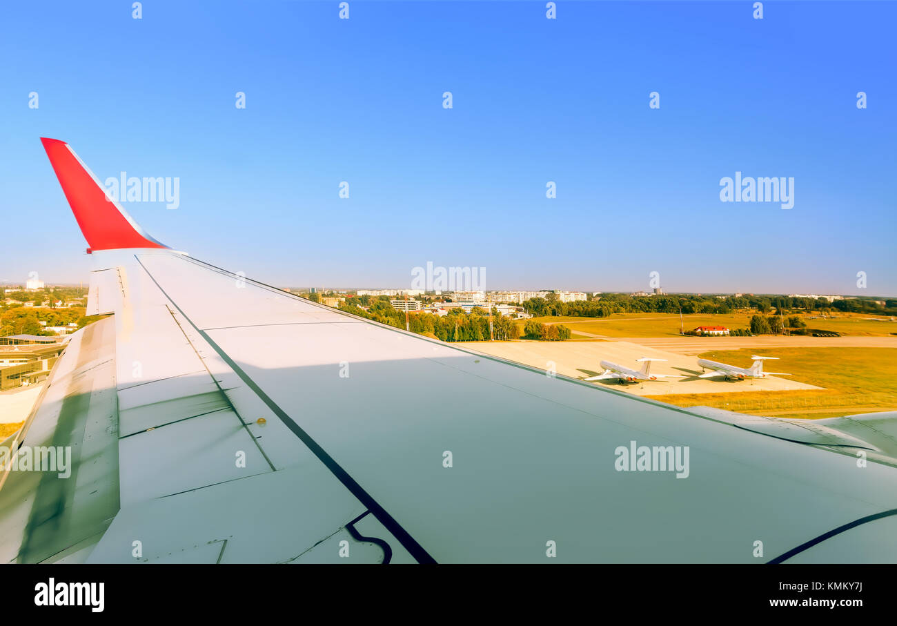 View of the airport of the big city's house from the window, above the wing of the takeoff aircraft Stock Photo