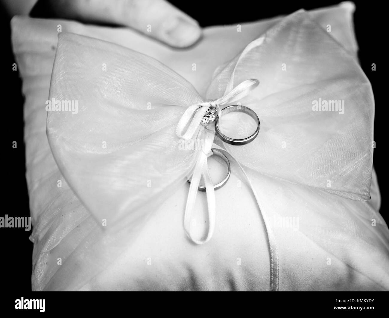 the wedding rings lie on the pillow in black and white Stock Photo