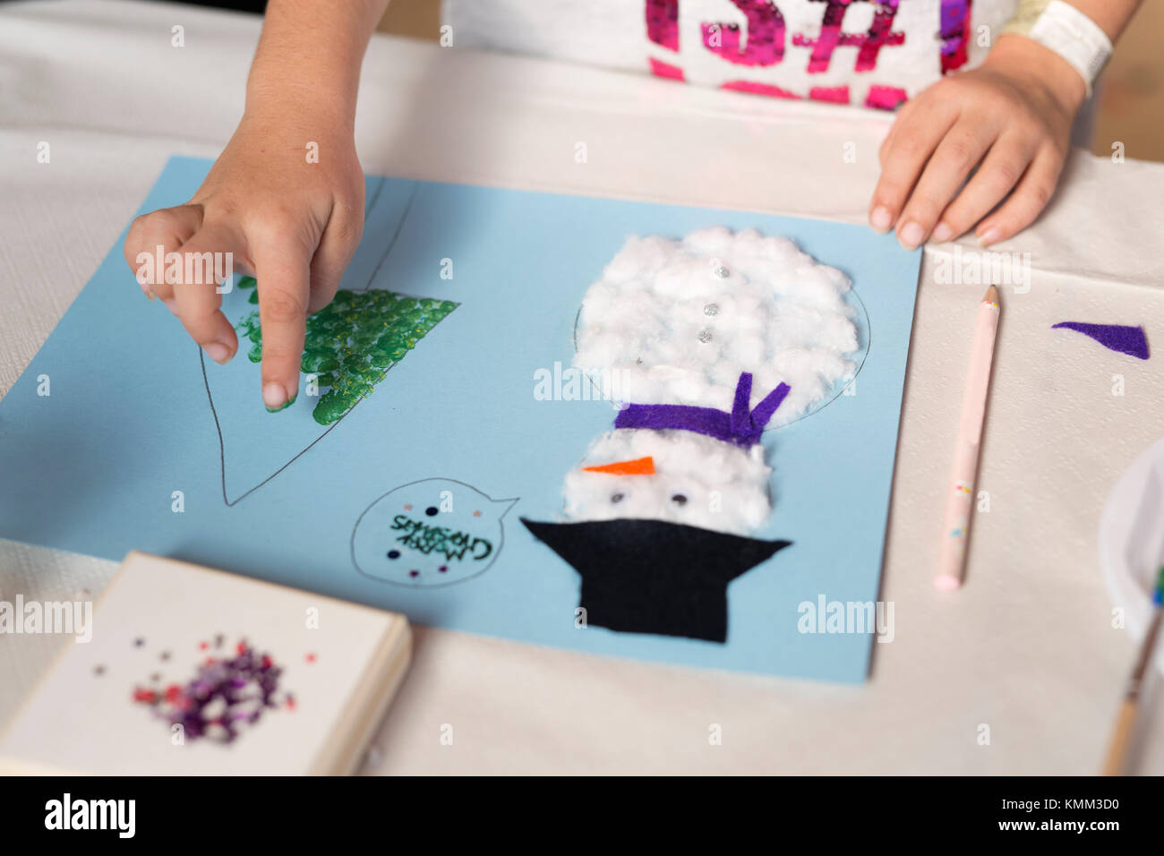 Hands of a 10 year old girl doing a Christmas craft. Horizontal shot