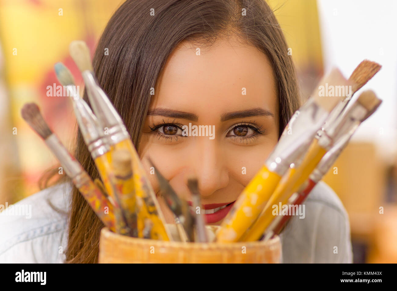 Beautiful young woman painter with color palette and paint brush in ...