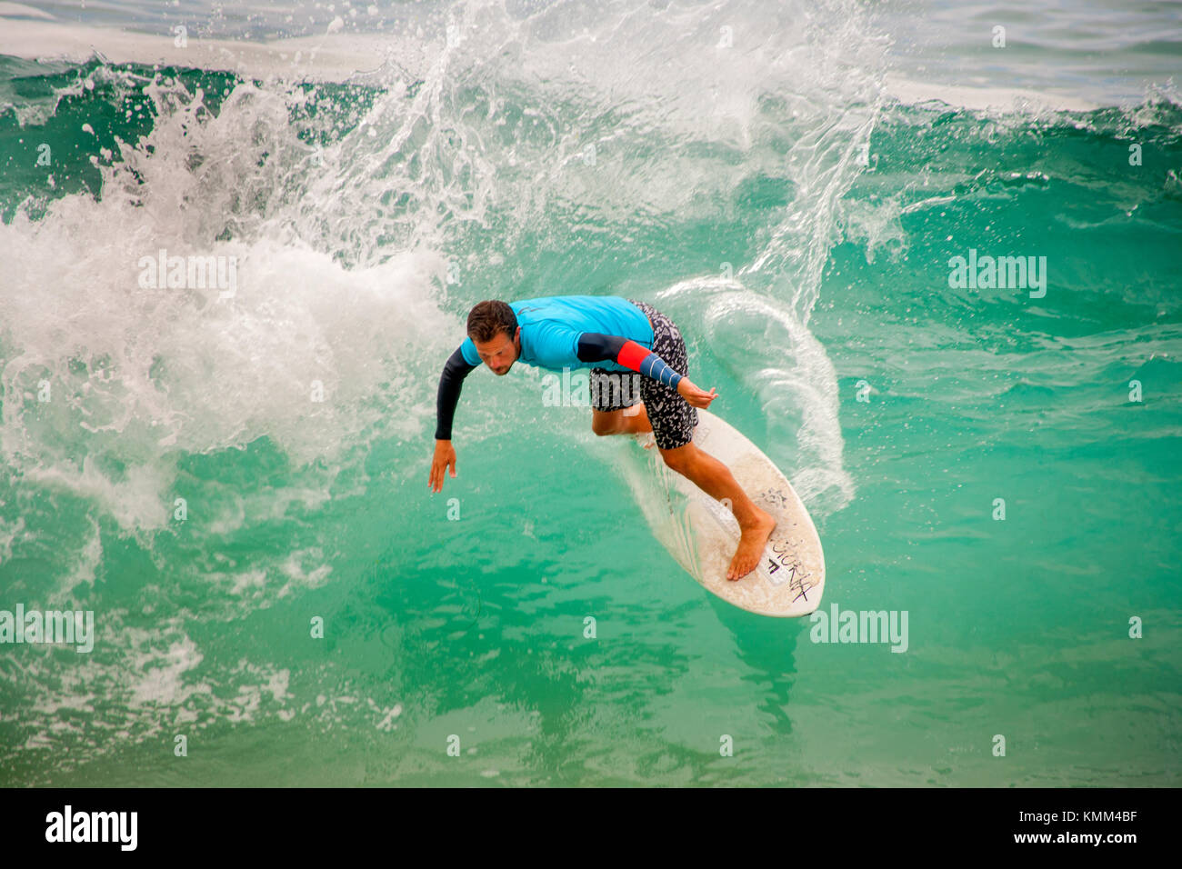 Carefully keeping his balance, a surfer rides the waves on a skimboard