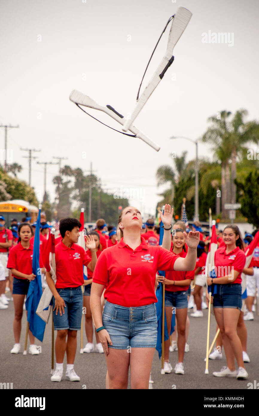 Dummy rifles are tossed with precision by high school host band marchers at a city anniversary parade in Fountain Valley, CA. Stock Photo