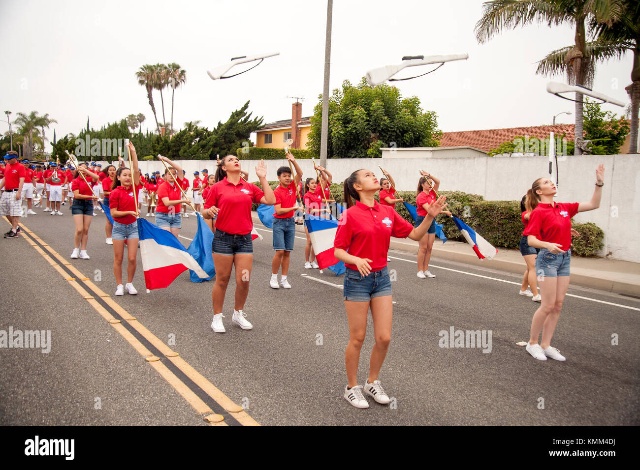 Dummy rifles are tossed with precision by high school host band marchers at a city anniversary parade in Fountain Valley, CA. Stock Photo