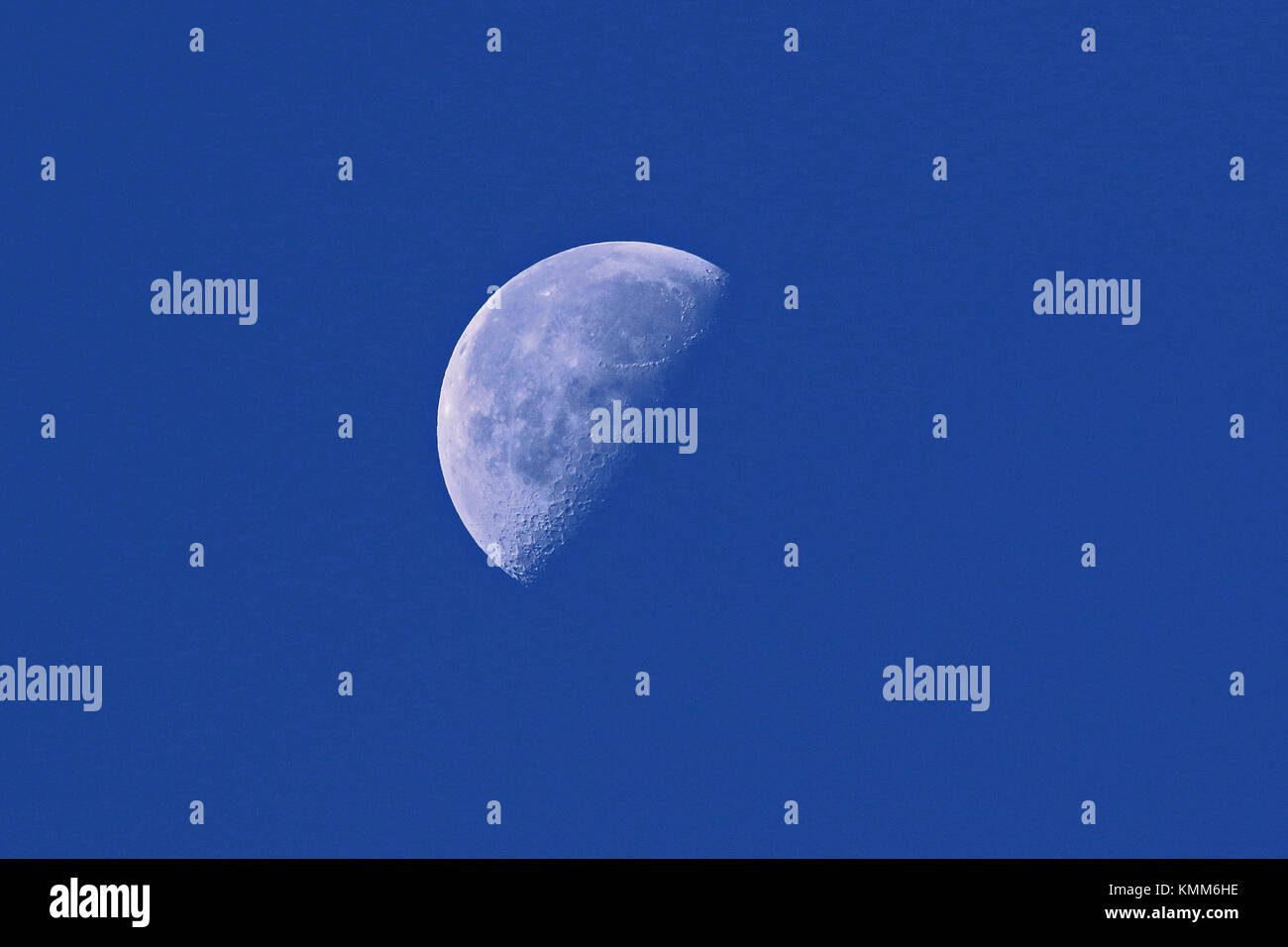 waxing moon in its first quarter in early morning daylight in Italy in