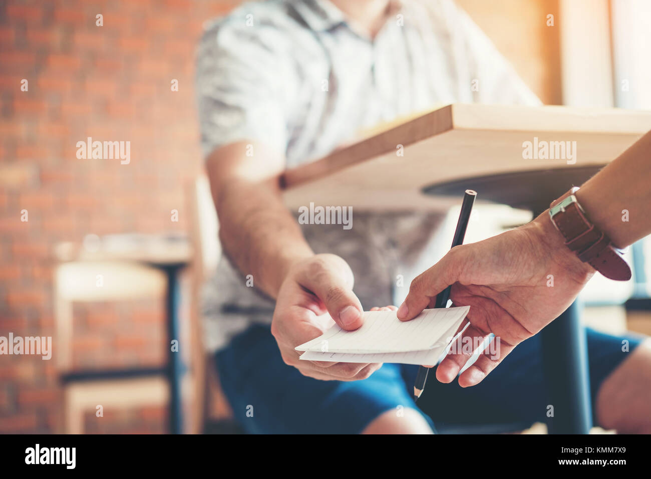 University high school students passing note test cheating the exam in the classroom. Stock Photo
