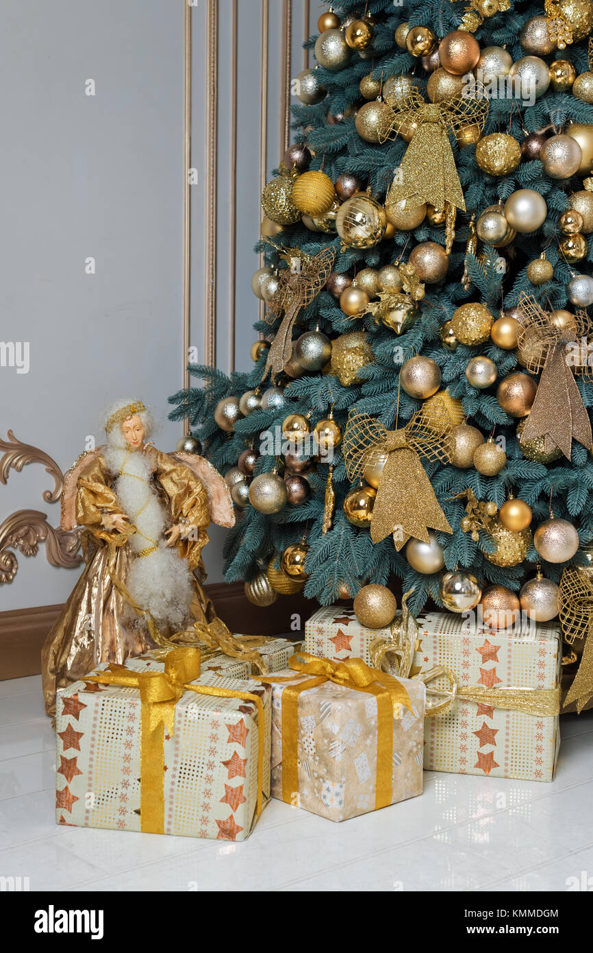 Beautiful decorated golden Christmas tree with present boxes in luxury ...