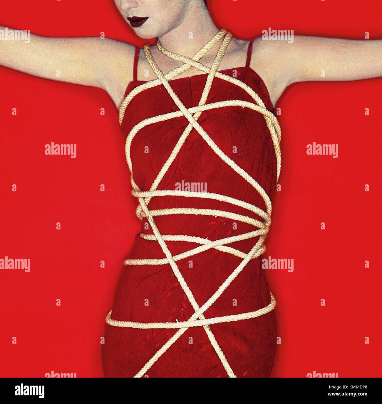 Lady in red dress tied with a rope Stock Photo Alamy