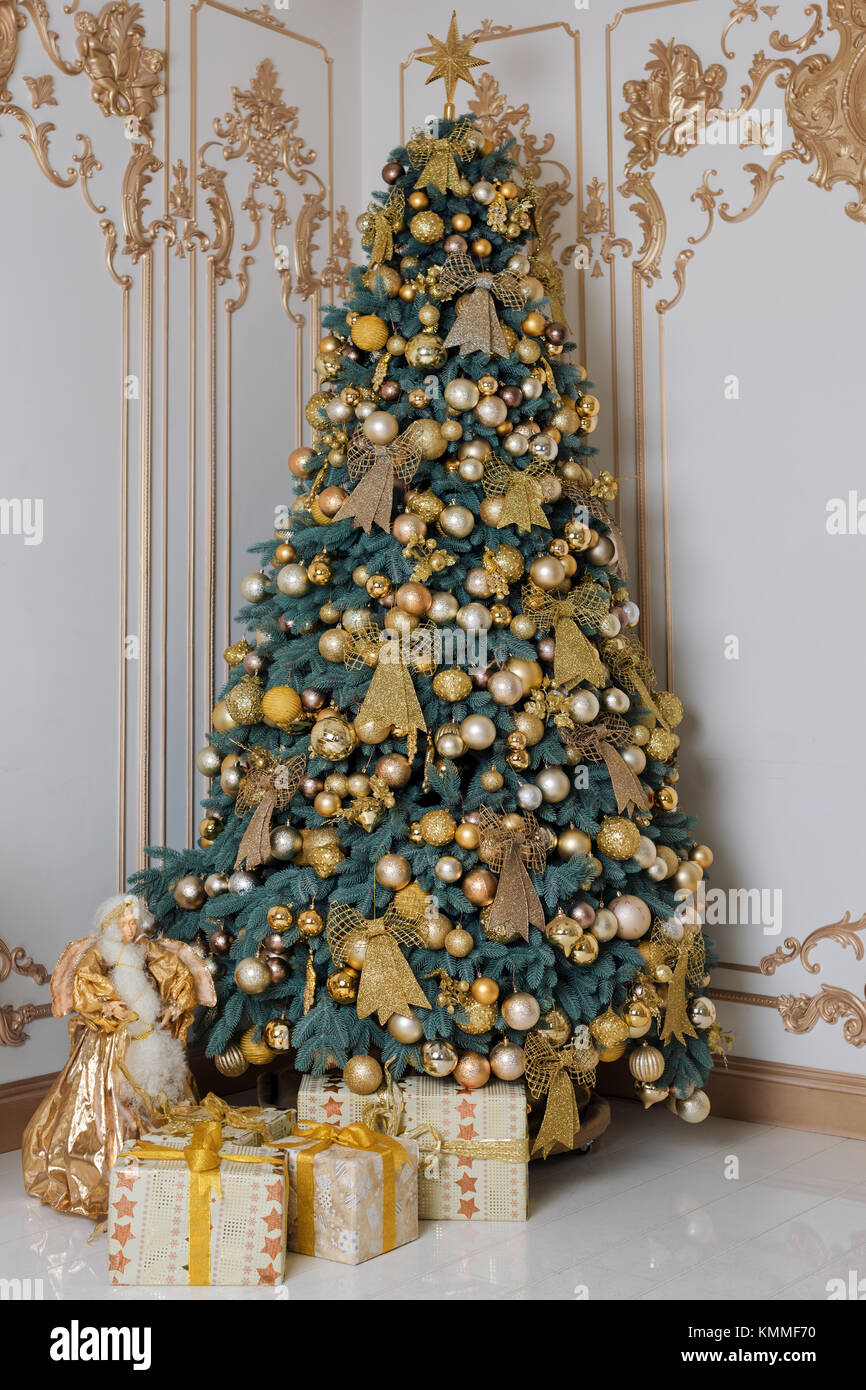Beautiful decorated golden Christmas tree with present boxes in luxury ...