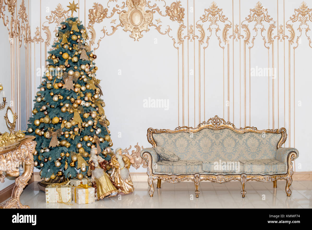 Beautiful decorated golden Christmas tree with present boxes in luxury ...