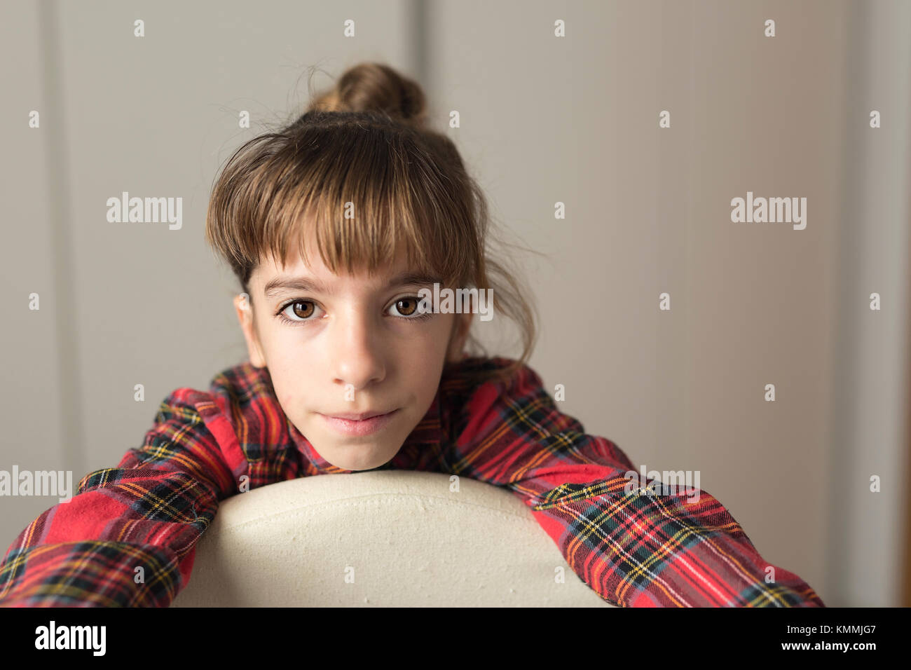 Portrait of a 10 year old girl sitting on a chair. Horizontal shot