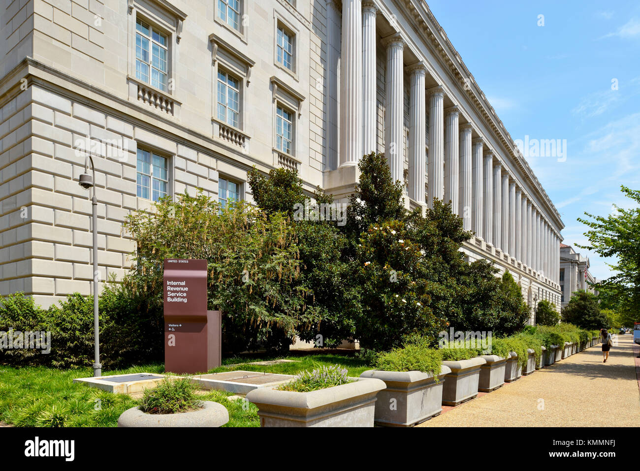 WASHINGTON, DC, USA - MARCH 4, 2012: A woman walks by the Internal Revenue Service building in Washington, DC. A small IRS sign in the corner of the b Stock Photo