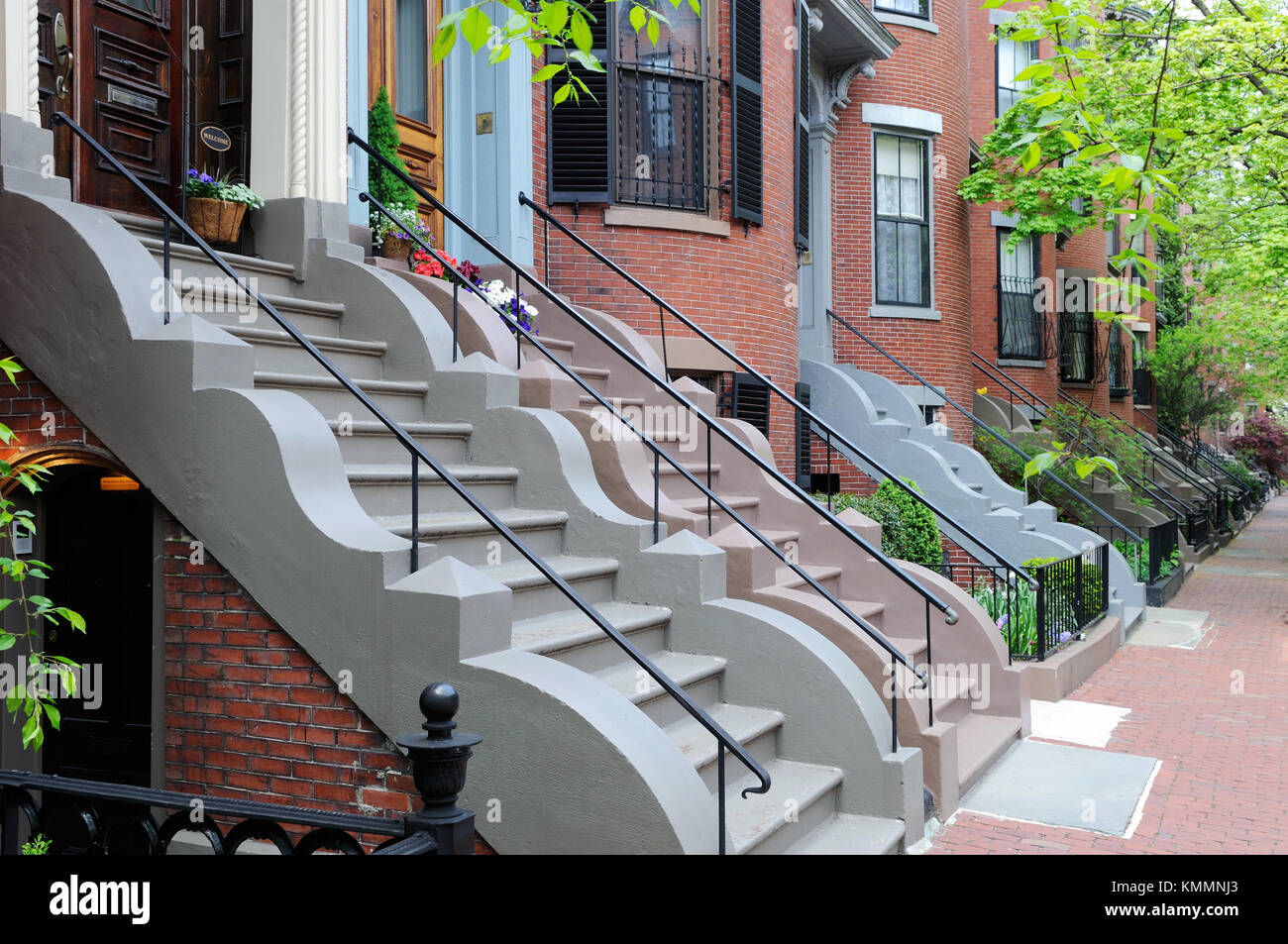 South End, Boston Victorian row houses. Brick aparment buildings and sidewalks, colorful steps with wavy stone trim, cast iron railings and fences, un Stock Photo