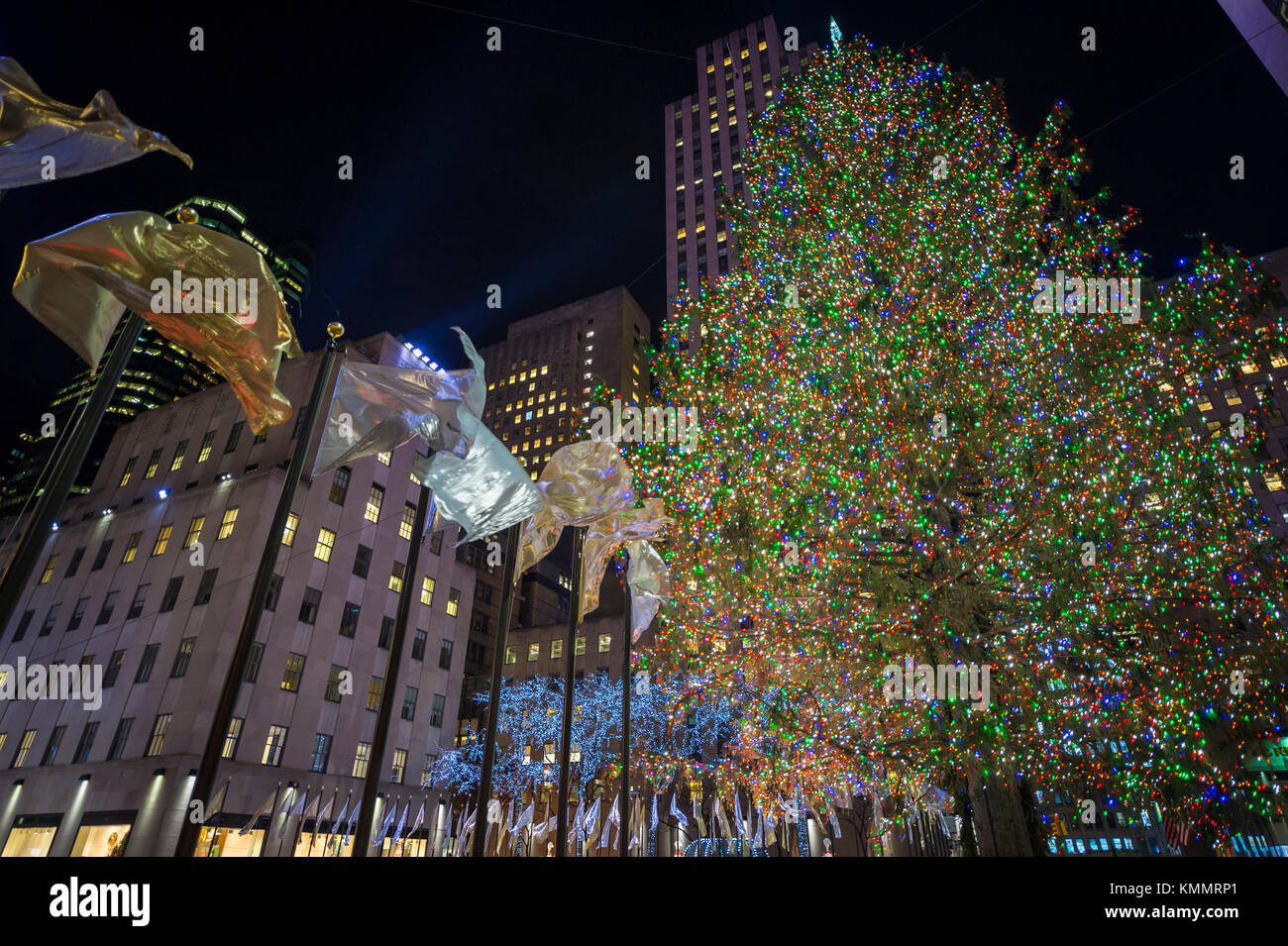 Holiday flags fly around the central plaza in front of the Rockefeller Center Christmas Tree, one of New York City's top winter tourist attractions Stock Photo
