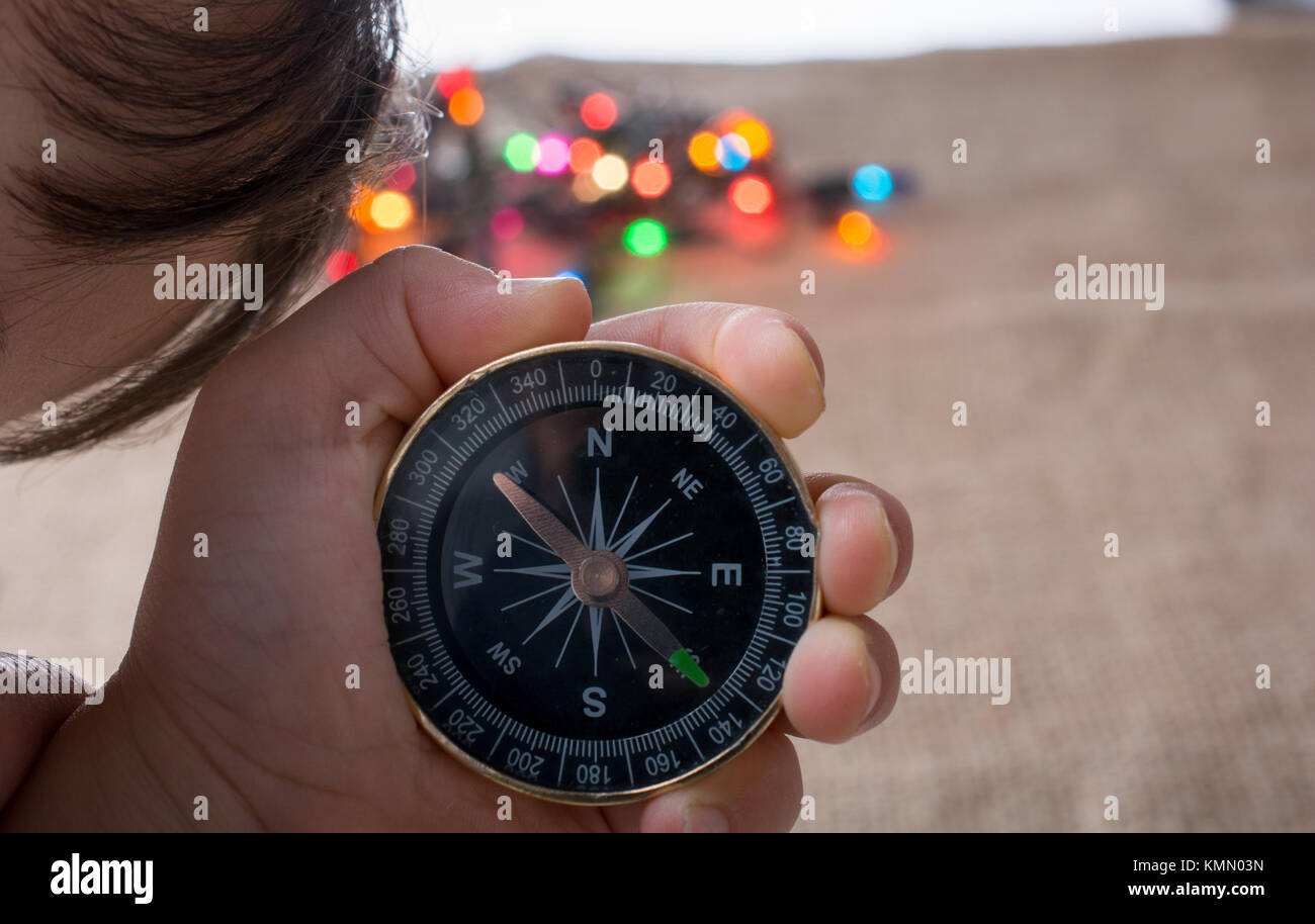Hand holding a compass before colorful lights Stock Photo - Alamy