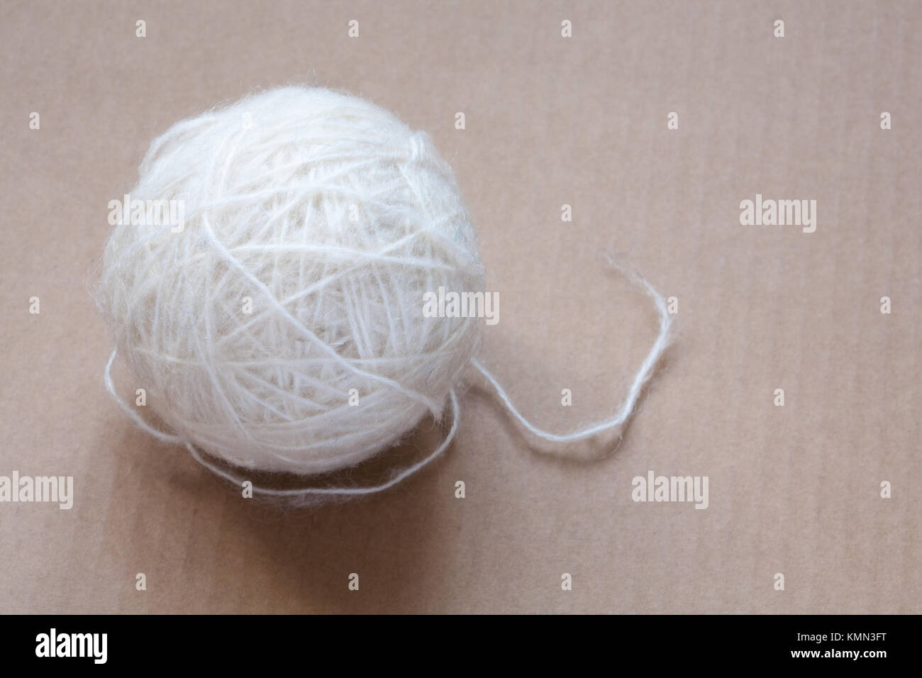 Ball of white wool yarn on cardboard background Stock Photo - Alamy
