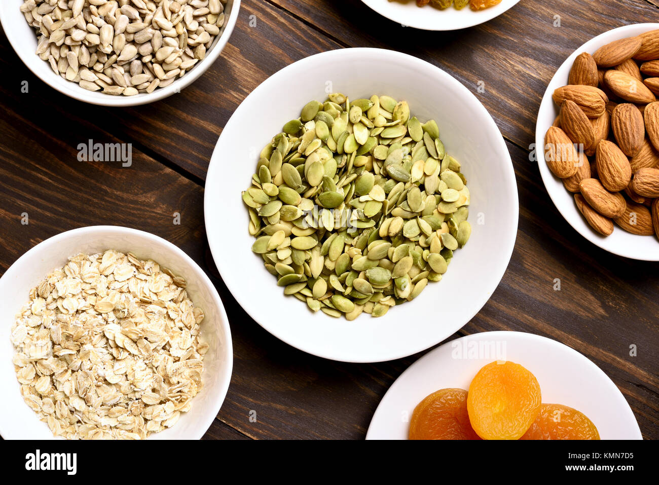 Ingredients for cooking granola on wooden table. Healthy snack in bowl. Top view, flat lay Stock Photo