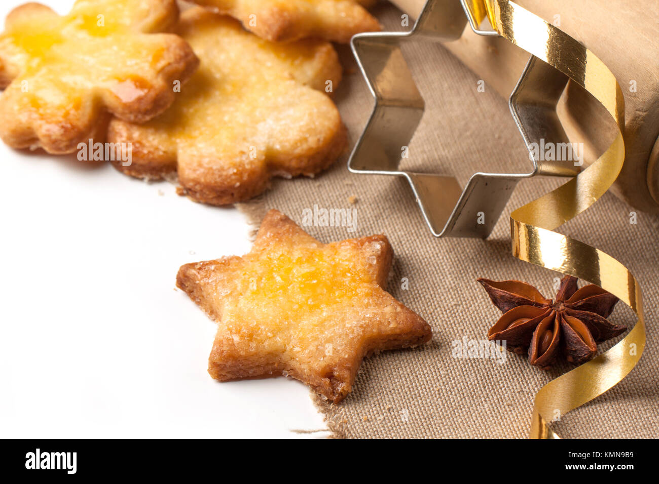 Close up of homemade sugar cookies with metal cookie cutters and golden tape over white Stock