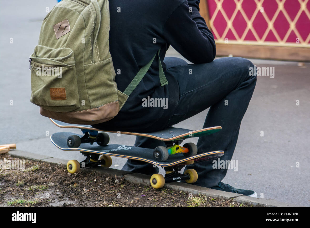 back view skater with backpack sits on two boards Stock Photo Alamy